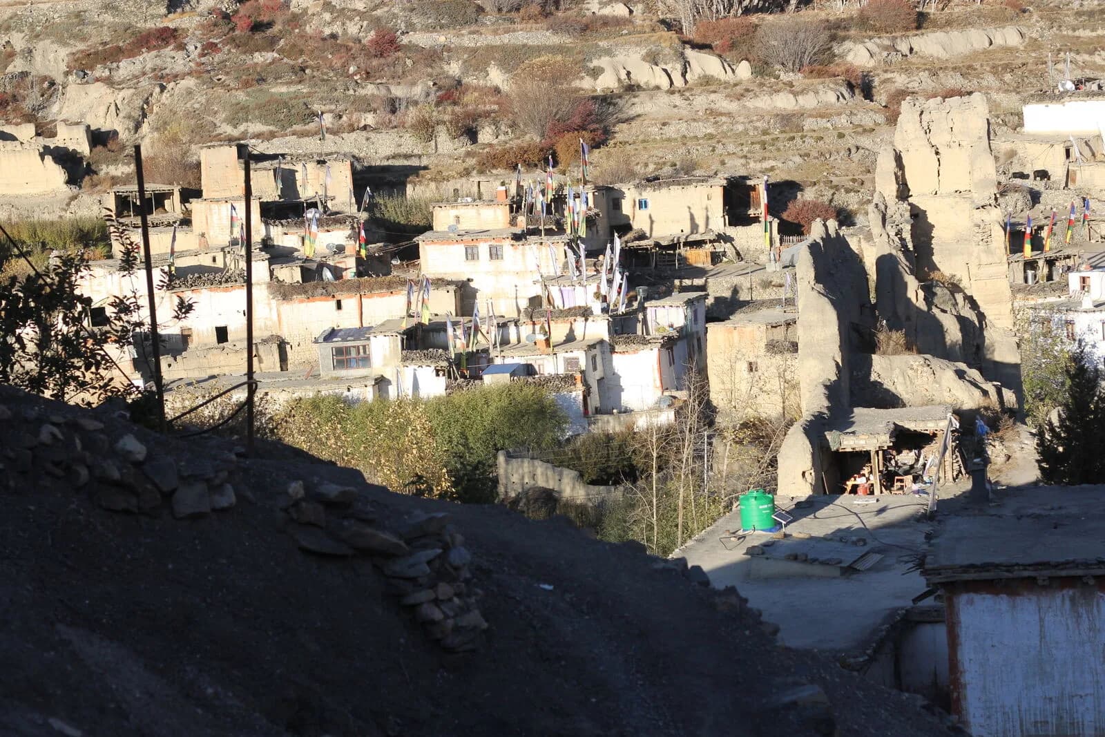 A flat-roofed mud-brick village stacked above a dry river valley.